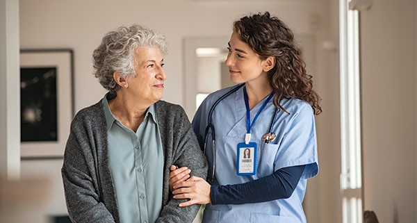 an elegant elderly smiling at a carer in her home